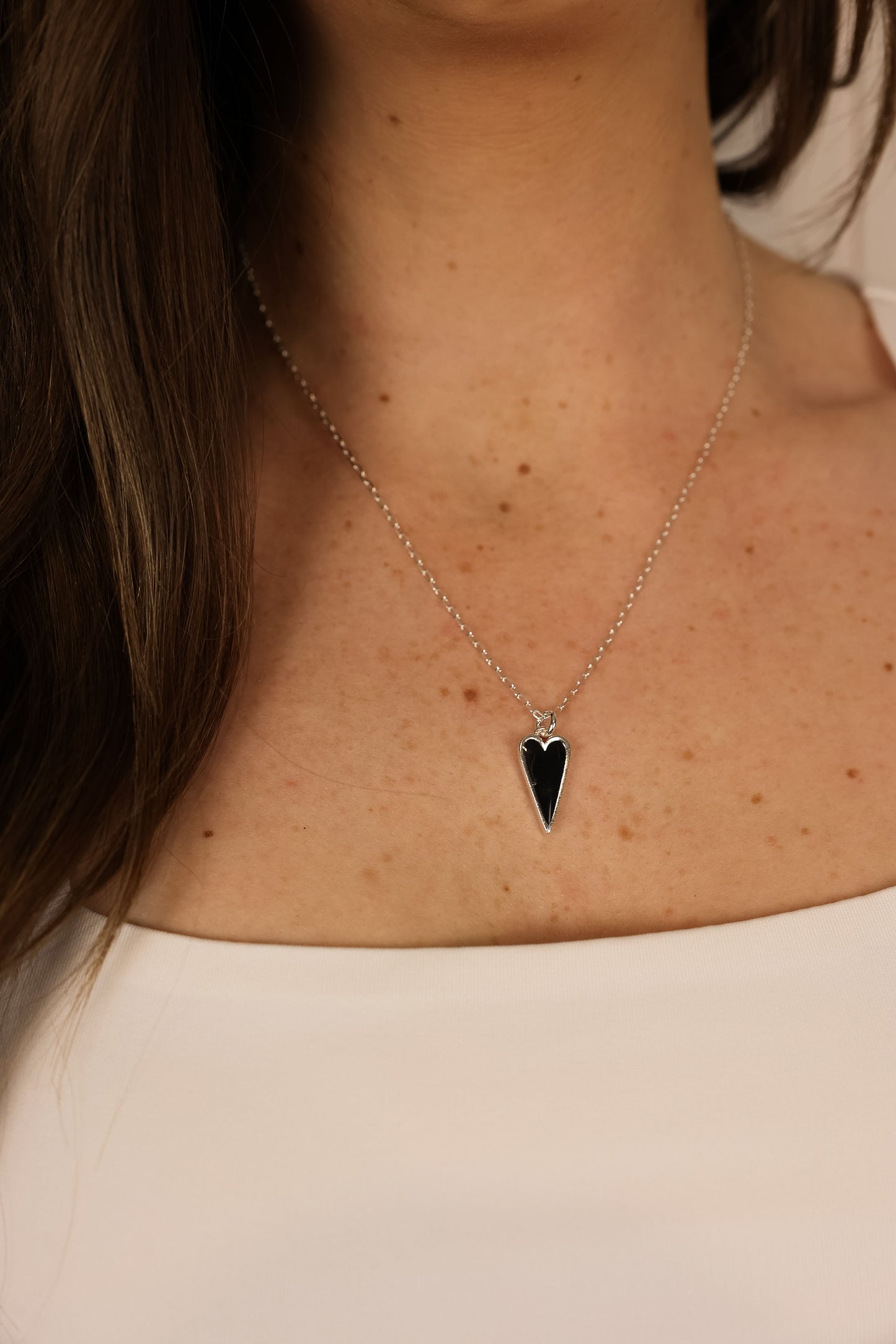Heart pendent necklace on a delicate chain. Pendant is made of black clay pressed into silver metal.