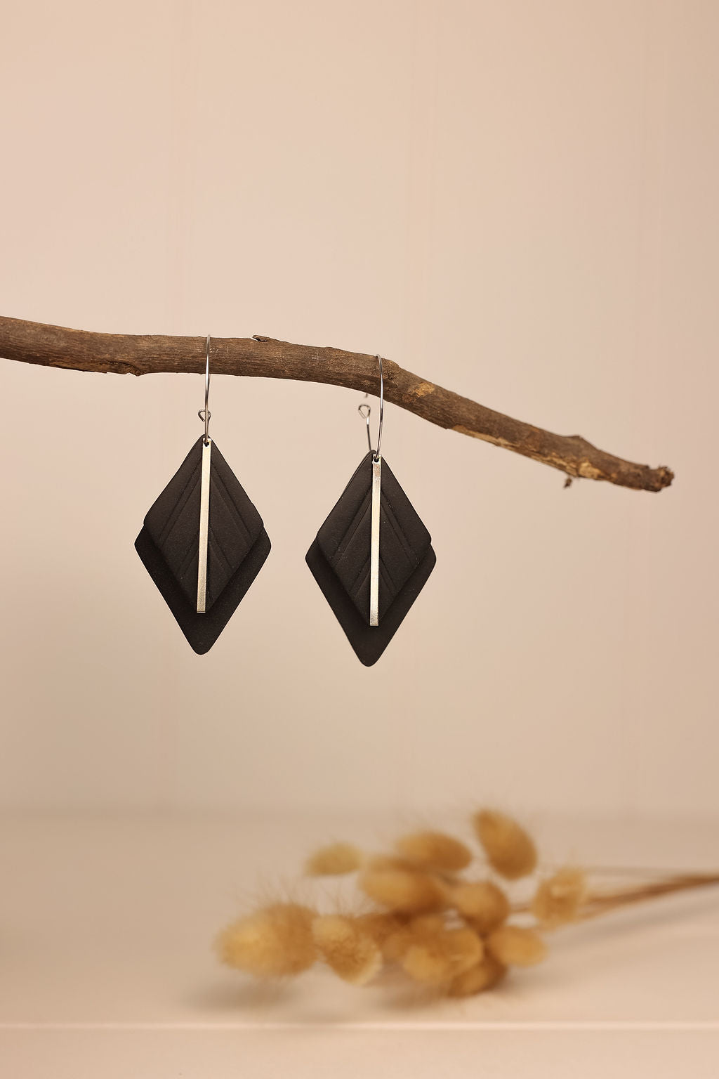 diamond shaped clay earrings in black with silver accents.