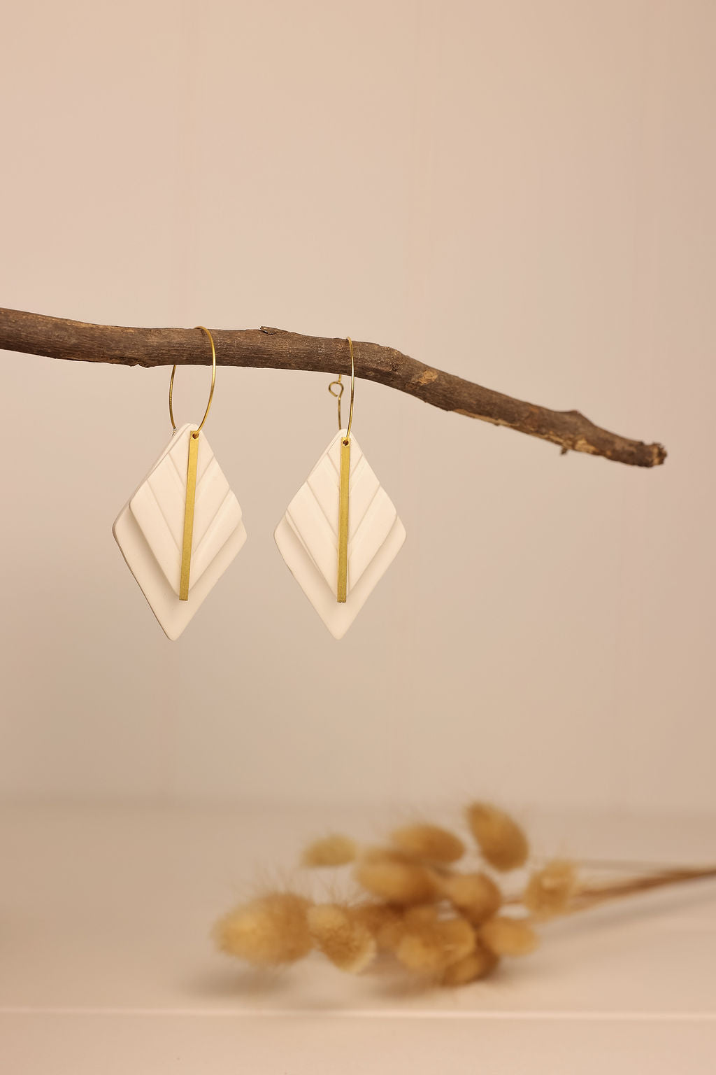 white diamond shaped earring with gold accent