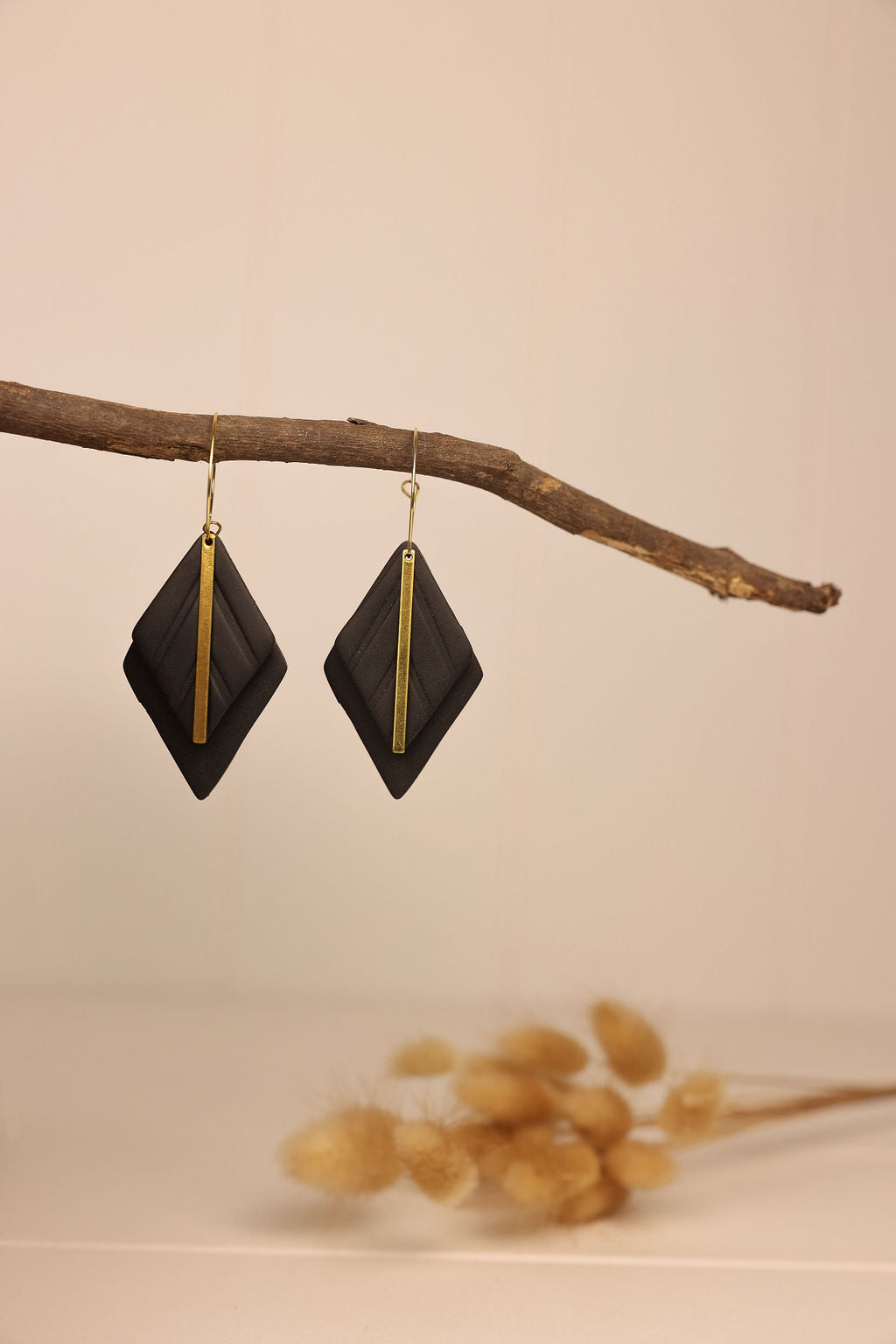 black clay diamond shaped earring with gold accents