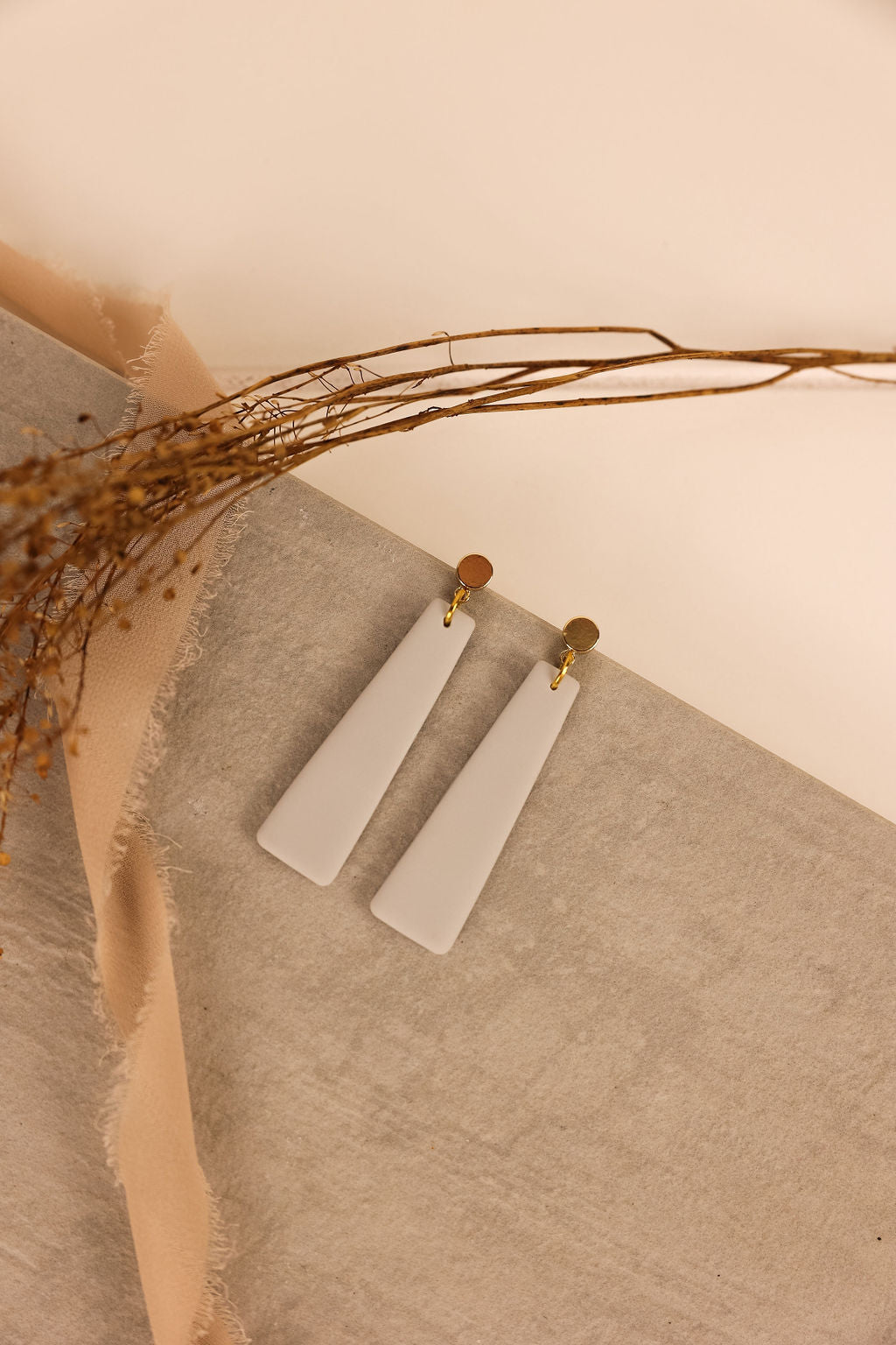 nora earring in grey with gold ear posts.