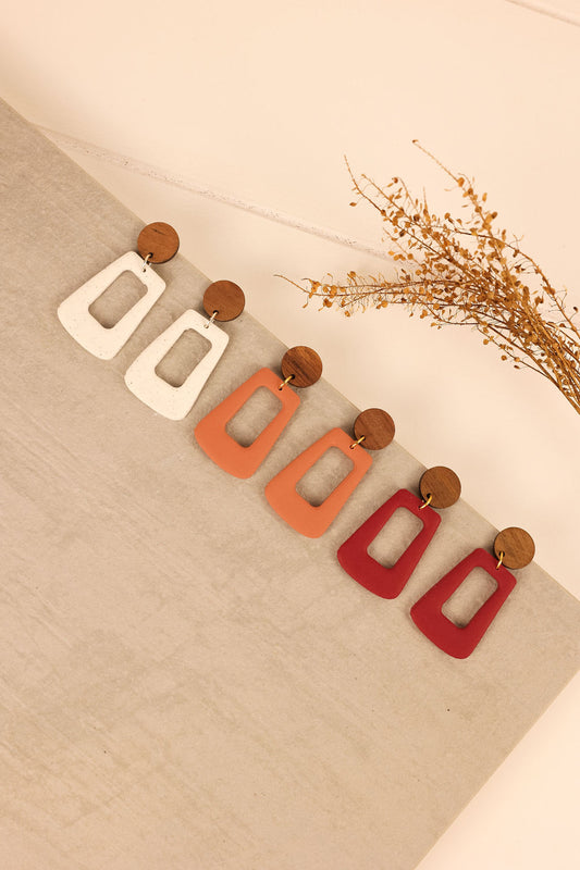 close up picture of trapezoid shaped clay earrings on a charm.