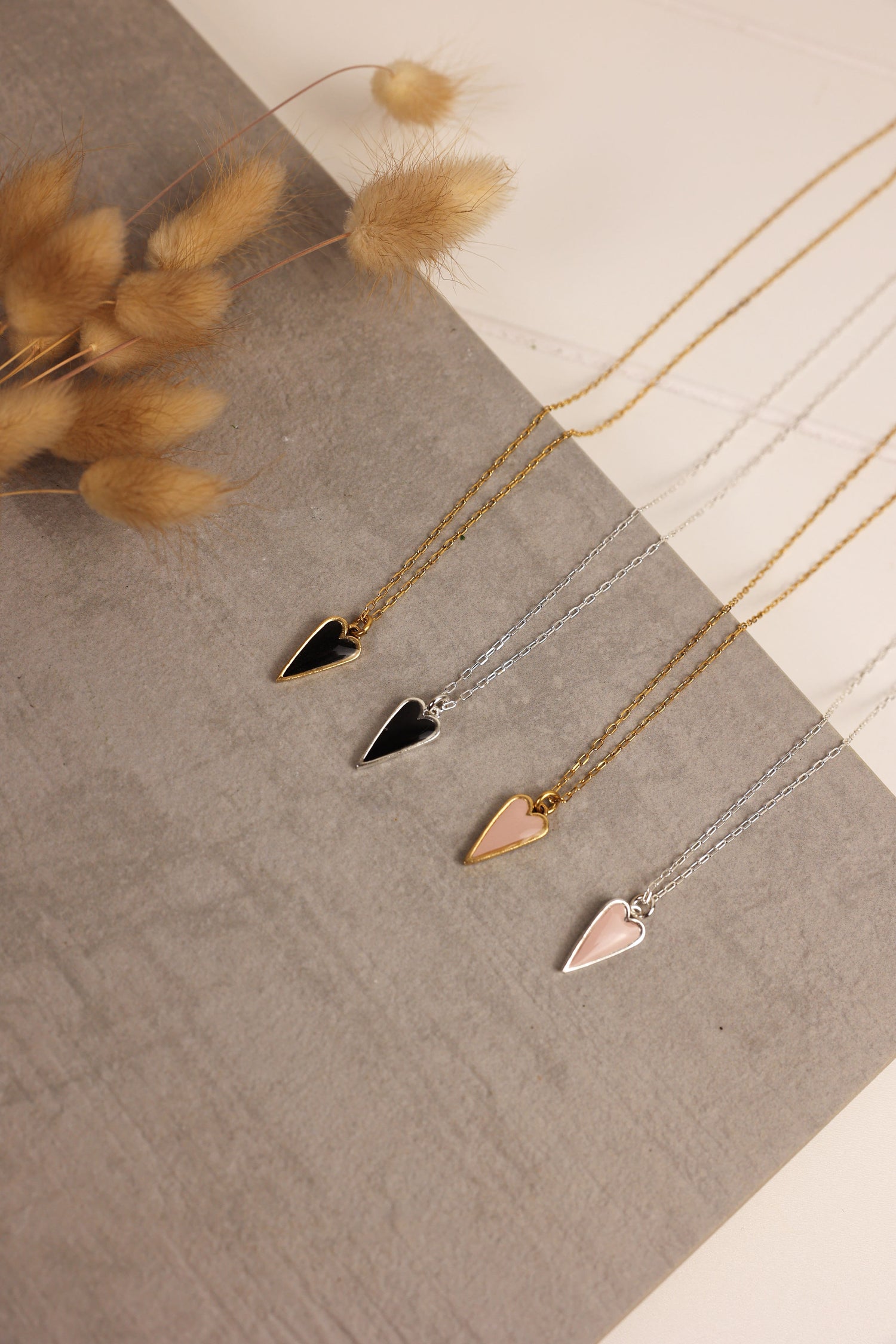 Heart pendent necklace on a delicate chain. Pendant is made of clay pressed into metal. Available in pink or black with a gold or silver chain.