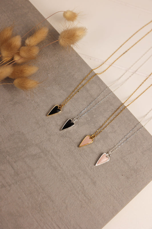 Heart pendent necklace on a delicate chain. Pendant is made of clay pressed into metal. Available in pink or black with a gold or silver chain.