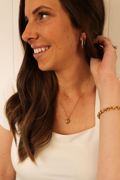 delicate gold heart necklace being worn by model.