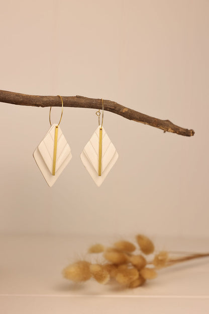 white diamond shaped earring with gold accent