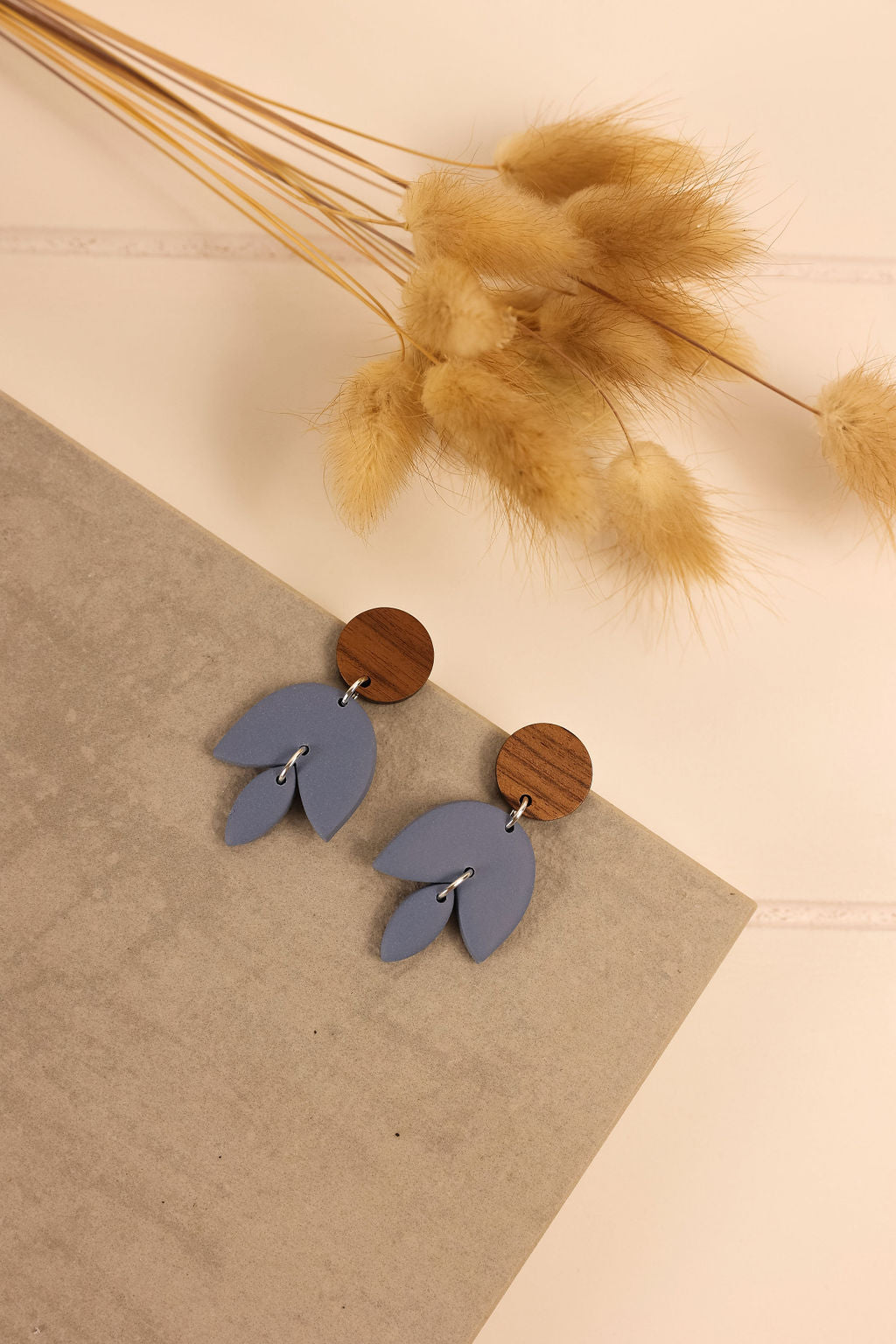 Freja earring in bluestone on a slate colored background. 