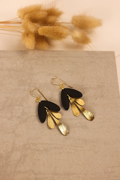 Modern Scandi earrings in gold with a black clay charm. 