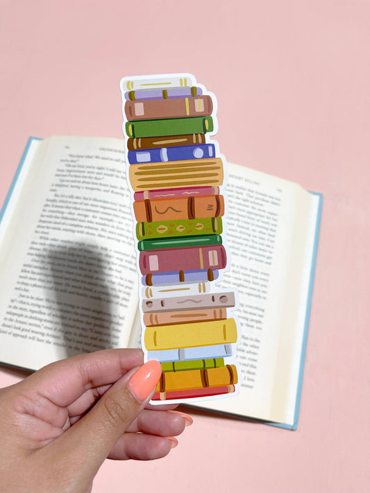 A die-cut bookmark featuring a stack of colorful books held in front of an open book.