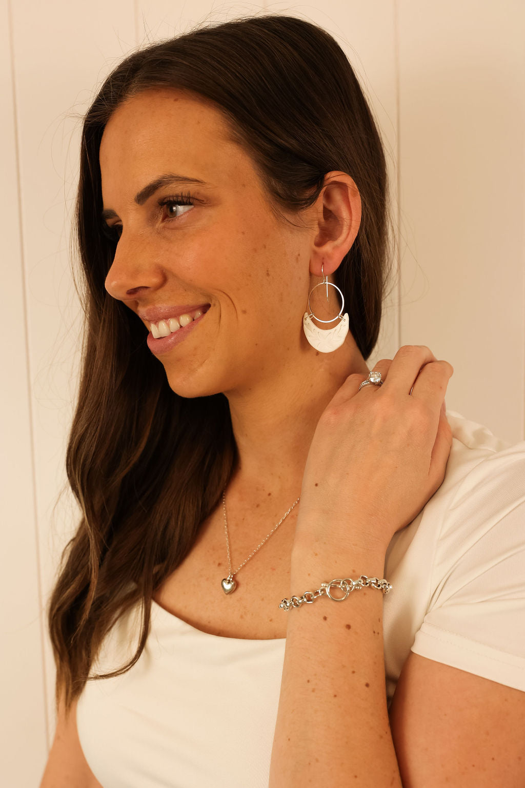 Model wearing the Luna earring in white with silver hardware. 