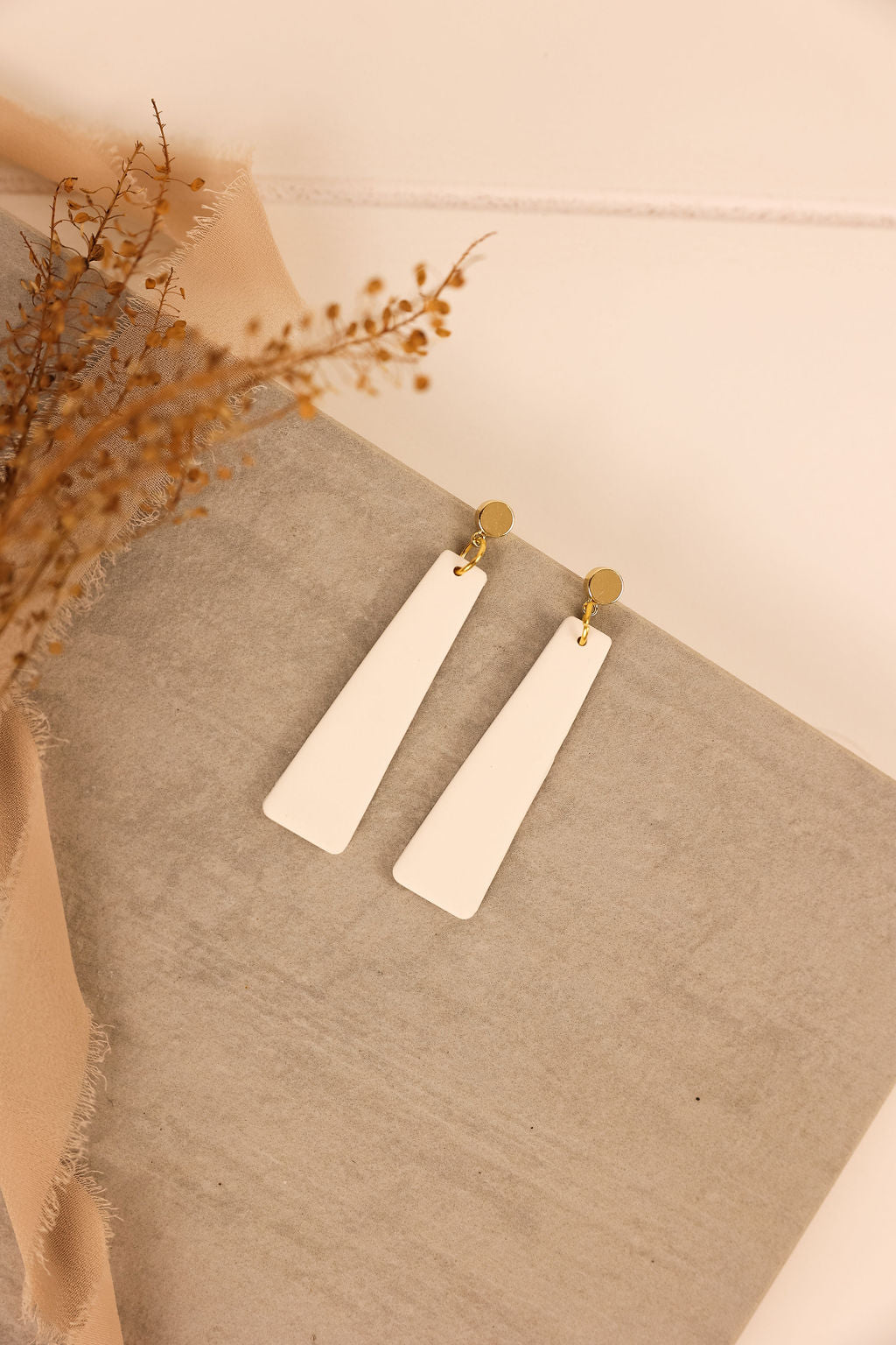 nora earring in white with gold hardware. 