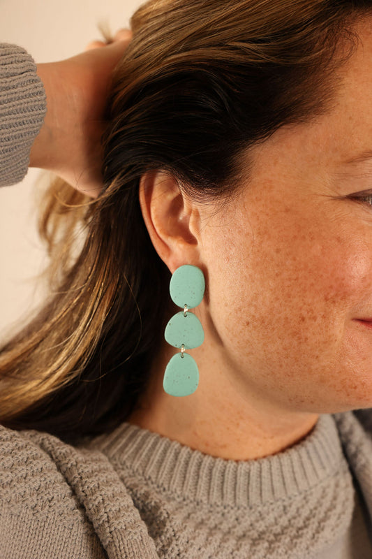 Stone drop earring worn by model. 